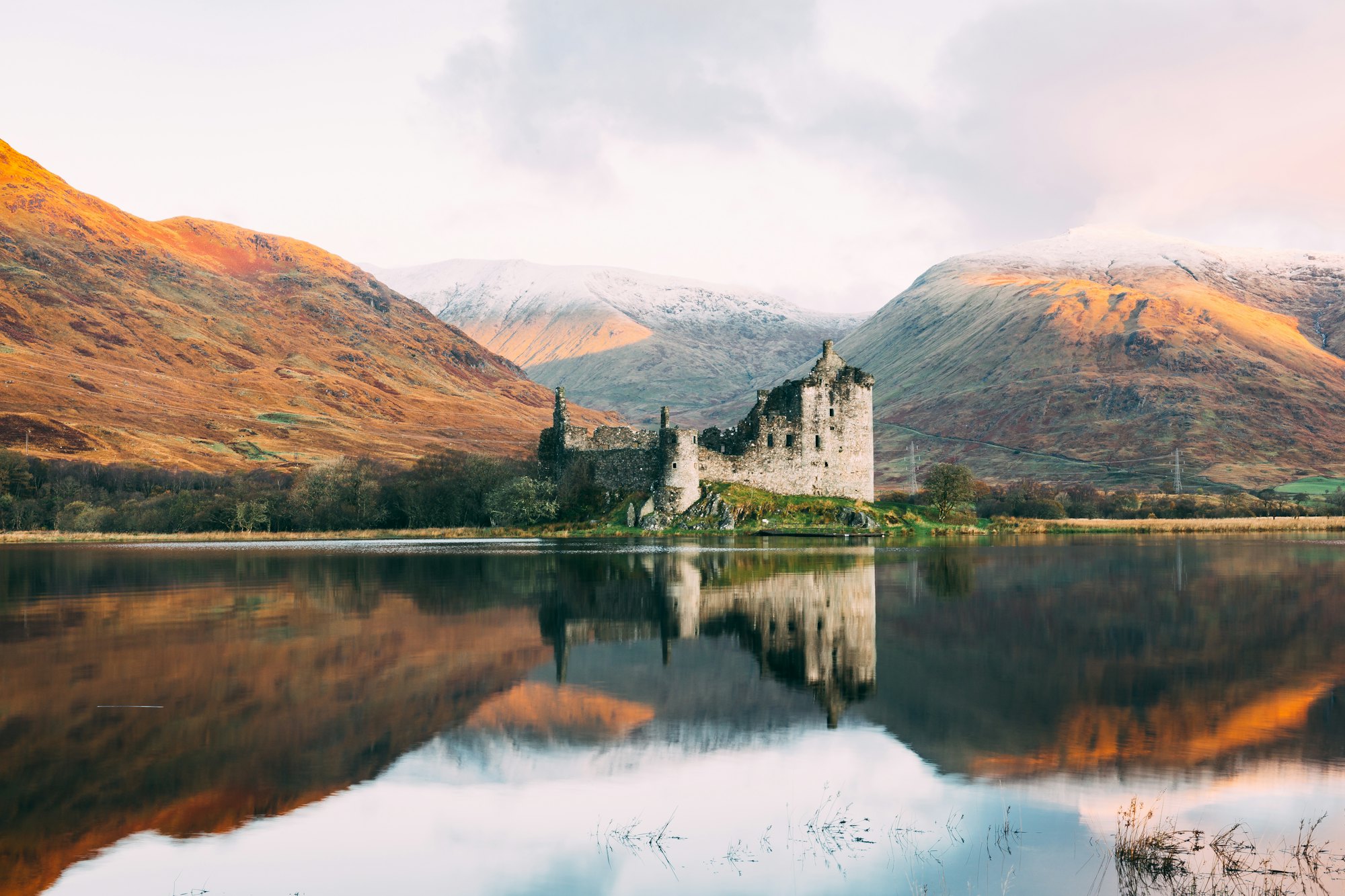 Kilchurn Castle on Loch Awe in autumn, the hills russet and gold under snow-dusted tops